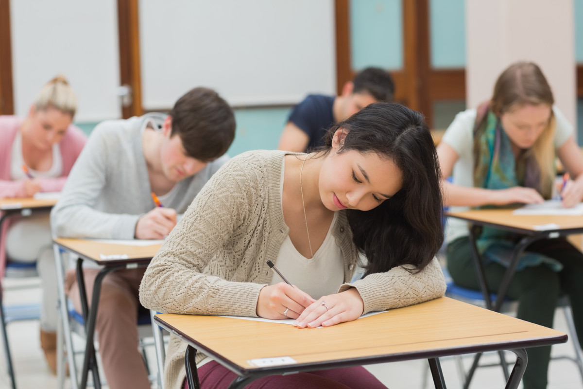 Exams in the usa. Студент на экзамене. Студенты пишут тест. Студент пишет. Студент за партой.